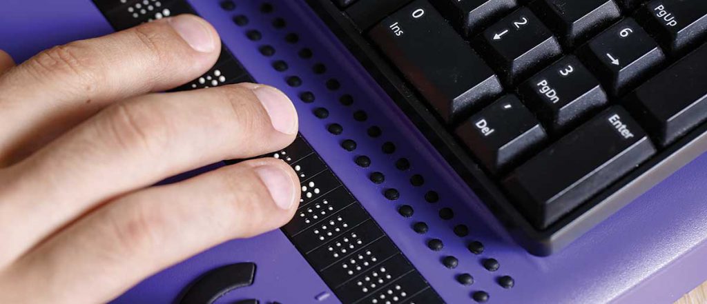 hands operating a Braille keyboard