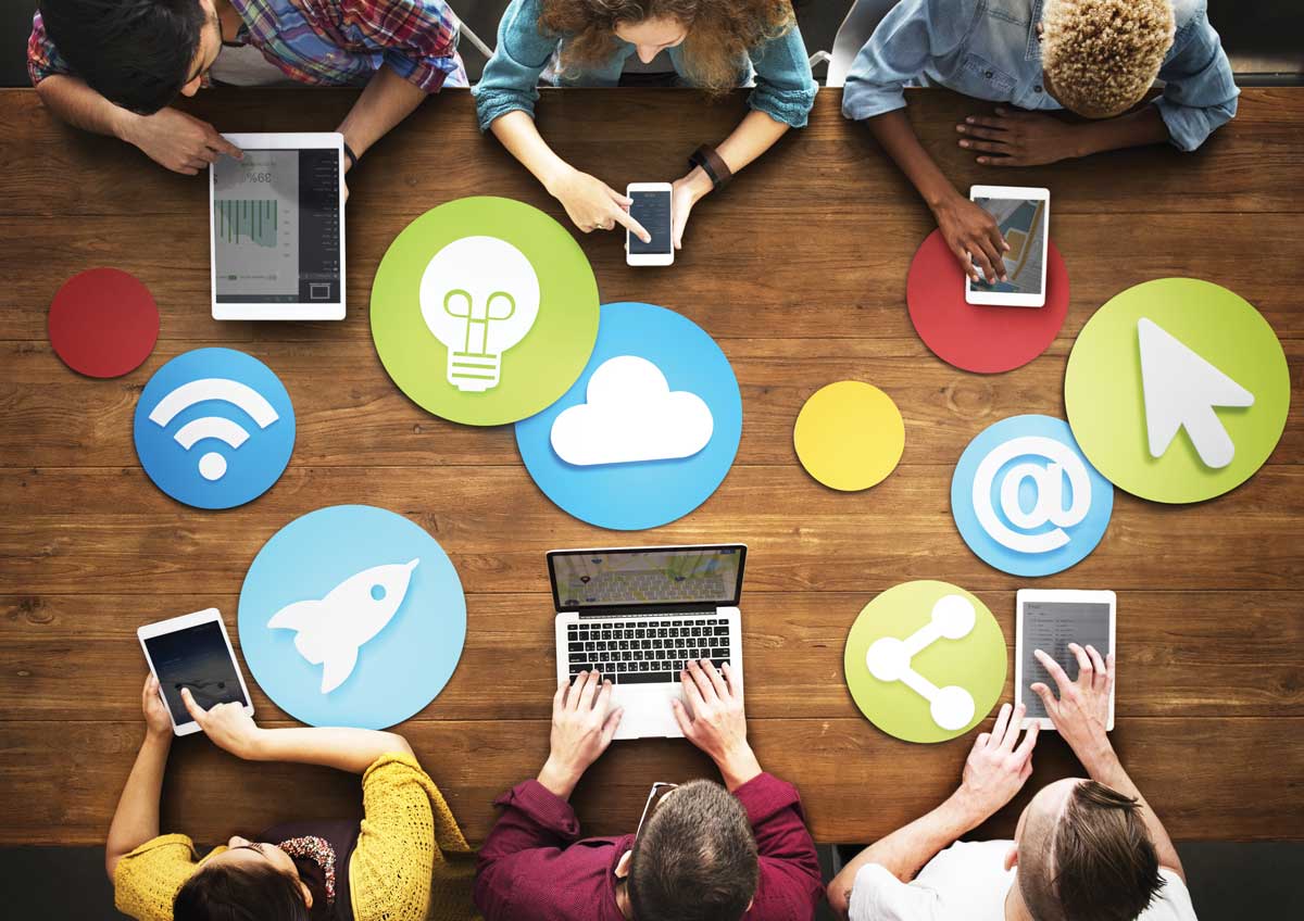 overhead view of people working on computers around a table