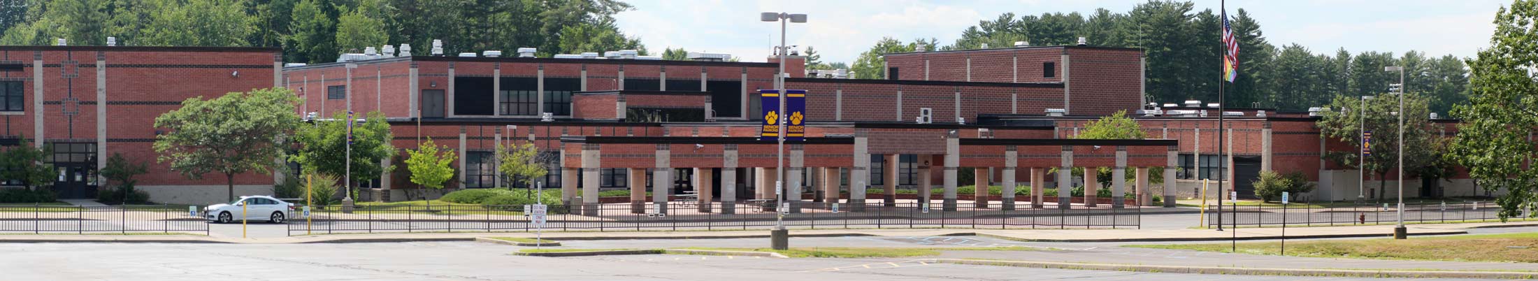 Brick school building entrance and parking lot